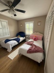 a bedroom with two beds and a ceiling fan at Njade & Luxury Stay in Spring Hill +39 photos