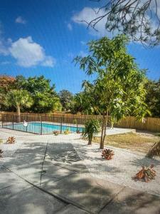 a swimming pool with a tree next to a fence at Njade & Luxury Stay in Spring Hill