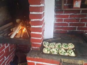 a brick oven with pizzas being baked in it at Cabana Duma la munte cu ciubar in Dealu Negru
