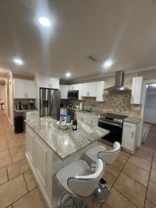a kitchen with white cabinets and a marble counter top at Njade & Luxury Stay in Spring Hill