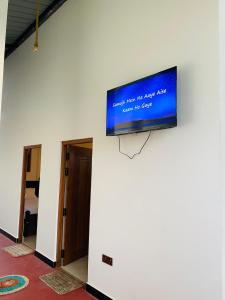a flat screen tv on the wall of a room at Sawmya Guest House in Randeniya