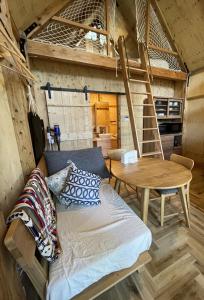 a bed in a room with a table and a ladder at 森のRetreat -foresta di luce- in Hatsukaichi
