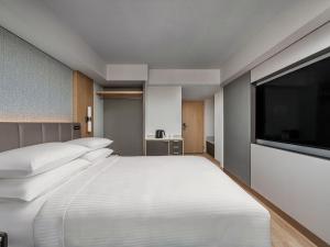 a bedroom with a large white bed and a flat screen tv at Hamamatsu Marriott Hotel in Hamamatsu