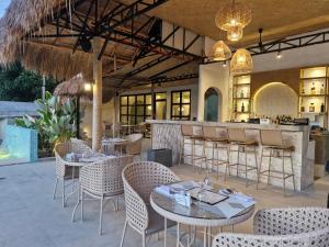 a restaurant with tables and chairs and a bar at Villa Alessandra Homestay in Moalboal