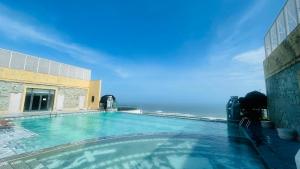 a swimming pool with the ocean in the background at Sea La Vie Tuy Hoa Beachside Studio in Tuy Hoa