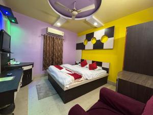 a bedroom with a bed and a desk and a tv at Hotel Kep's - A Business Class Hotel in Contai