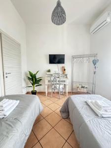 a white room with two beds and a table at Tommy's Apartment in Pompei