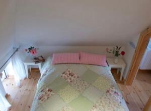 a bedroom with a bed with pink pillows on it at Alte Boddenkate in Born