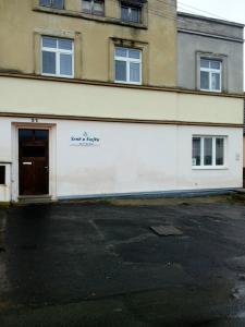 a white building with a door on the side of it at Šenk u Švejka in Ústí nad Labem