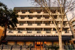 a tall white building with a sign that reads the north building at Ephesus Nobel Otel in Selçuk