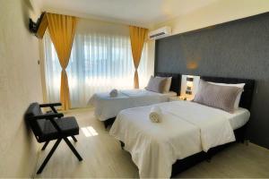 a hotel room with two beds and a chair at Ephesus Nobel Otel in Selçuk +37 photos