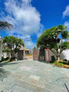 a driveway with a gate and palm trees at Happy Villa in Phú Hiệp