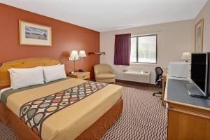 a hotel room with a bed and a television at Super 8 by Wyndham Crystal Lake in Crystal Lake