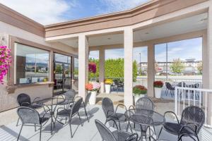 a patio with tables and chairs and windows at Super 8 by Wyndham Kelowna BC in Kelowna