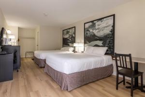 a hotel room with two beds and a desk at Super 8 by Wyndham Golden in Golden
