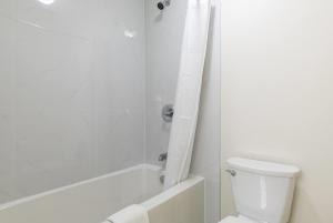 a white bathroom with a toilet and a shower at Super 8 by Wyndham Golden in Golden +23 photos