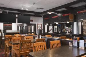 a restaurant with tables and chairs and a bar at Travelodge by Wyndham Cambridge - Waterloo in Cambridge