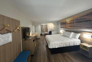 a hotel room with a bed and a television at Days Inn by Wyndham Royston in Royston