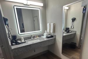 a bathroom with a sink and a mirror at Days Inn by Wyndham Royston in Royston