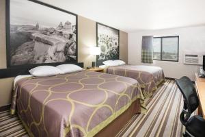 a hotel room with two beds and a desk at Super 8 by Wyndham Jamestown in Jamestown +5 photos