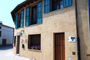 Un edificio con una puerta y una ventana con flores moradas. en El Capricho de Ana, en Neila de San Miguel