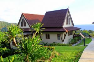 dom z metalowym dachem na zielonym trawniku w obiekcie Baan KanTiang See Villas - SHA Extra Plus w mieście Ko Lanta