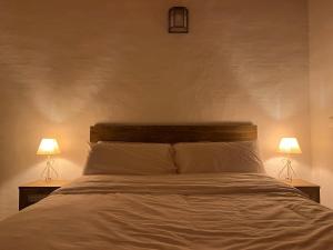 a bedroom with a white bed with two lamps at Balearic Sunset Apartment in Santa Gertrudis de Fruitera