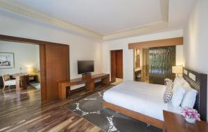a hotel room with a bed and a television at Grand Hyatt Doha Hotel & Villas in Doha