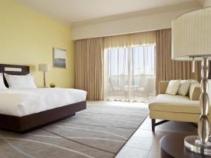 a hotel room with a bed and a couch at Grand Hyatt Doha Hotel & Villas in Doha