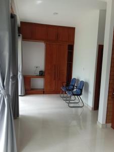 two blue chairs in a room with a kitchen at Leon Hilltop Resort in Kitulgala +24 photos