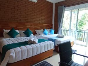 a bedroom with two beds with towels on them at Leon Hilltop Resort in Kitulgala
