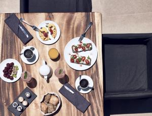 un tavolo in legno con piatti di cibo sopra di Cavo Tagoo Santorini a Imerovigli