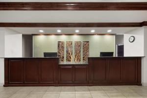 a lobby with a reception desk and a mirror at La Quinta by Wyndham Savannah Airport - Pooler in Savannah +25 photos