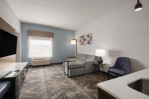 a living room with a couch and a chair at La Quinta by Wyndham Savannah Airport - Pooler in Savannah