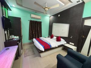 a bedroom with a bed and a couch and a television at Hotel Kep's - A Business Class Hotel in Contai