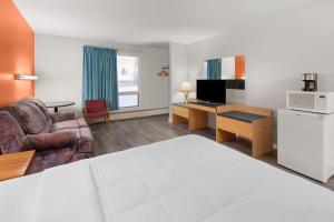 a living room with a couch and a desk with a microwave at Howard Johnson by Wyndham Edson in Edson
