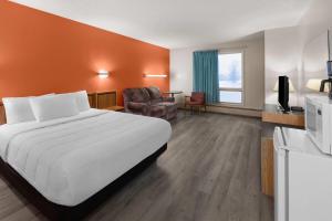 a hotel room with a large bed and a chair at Howard Johnson by Wyndham Edson in Edson