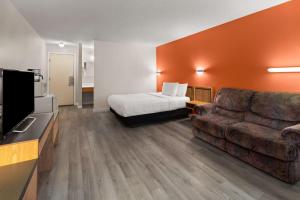 a hotel room with a bed and a couch at Howard Johnson by Wyndham Edson in Edson