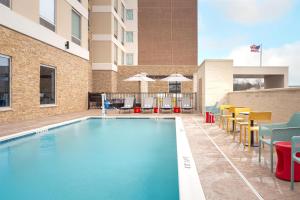 a swimming pool with chairs and a building at Tru By Hilton Spring Hill in Spring Hill