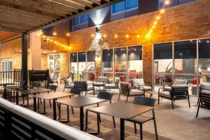 a patio with tables and chairs in front of a building at Home2 Suites By Hilton Spring Hill in Spring Hill