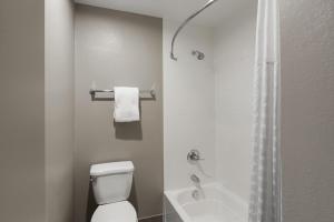 a white bathroom with a toilet and a shower at Wingate by Wyndham Jackson in Jackson +18 photos