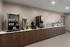 a kitchen with wooden cabinets and a counter top at Wingate by Wyndham Jackson in Jackson