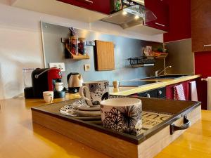 a kitchen with a counter with cups and plates on it at La Suite Privée - Maison Privative Spa & Sauna in Évreux