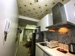 a kitchen with a sink and a stove at Azure North Monaco 10F Pool View with Netflix and WiFi and Karaoke in San Fernando +6 photos