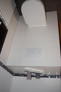 a white tiled floor in a bathroom with a sink at Quartier132 - Das All-Inklusive Ferienhaus in Öfingen