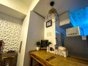a room with a table with a microwave and a clock at Azure North Monaco 10F Pool View with Netflix and WiFi and Karaoke in San Fernando