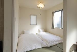 a bedroom with two white beds and a mirror at ev itoshima in Itoshima
