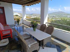 a table and chairs on a balcony with a view at Villa Rahes Kofini in Mykonos