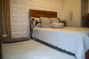a bedroom with a large bed and a bench at Azure North Monaco 10F Pool View with Netflix and WiFi and Karaoke in San Fernando