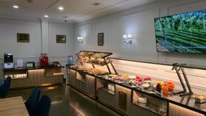 a buffet line with food on display in a restaurant at Janblue Hotel in Almaty